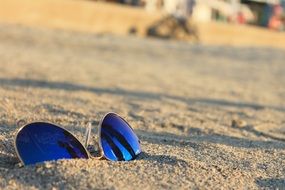 blue sunglasses on a sandy beach