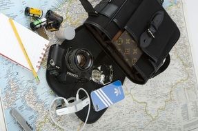 contax camera, film, notebook and pencil on map, travel concept