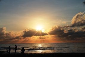 people silhouettes on coast at sunrise seascape