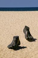 feet sculpture on the beach