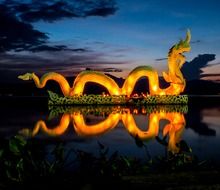 illuminated dragon figure on the lake at dusk