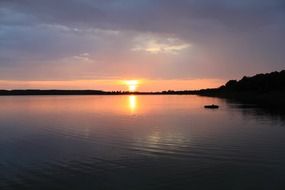 sunset on the background of calm water in the lake