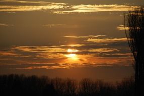 golden setting sun in the cloudy evening sky