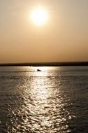 setting sun over the ocean near a tropical island