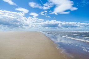 white clouds over the endless sandy beach