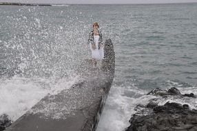 the wave covered the man on the pier