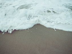 sea wave foam on beach sand