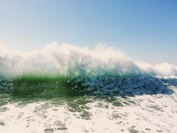 high waves of the ocean on a sunny beach