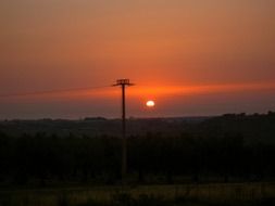 sunset behind a pillar with electricity