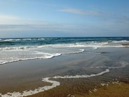 landscape of sea waves splashing on sand beach