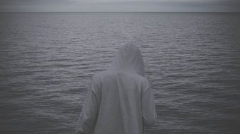 man in hoodie sweater on sea