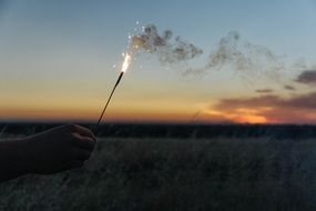 firework sparkler in hand sunset view
