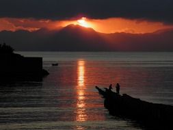 sunrise over the sea behind dark clouds