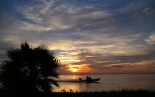 fishing boat in the ocean at sunset