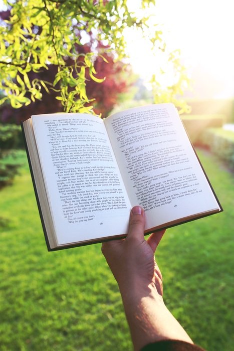 open book in hand at sunset, reading