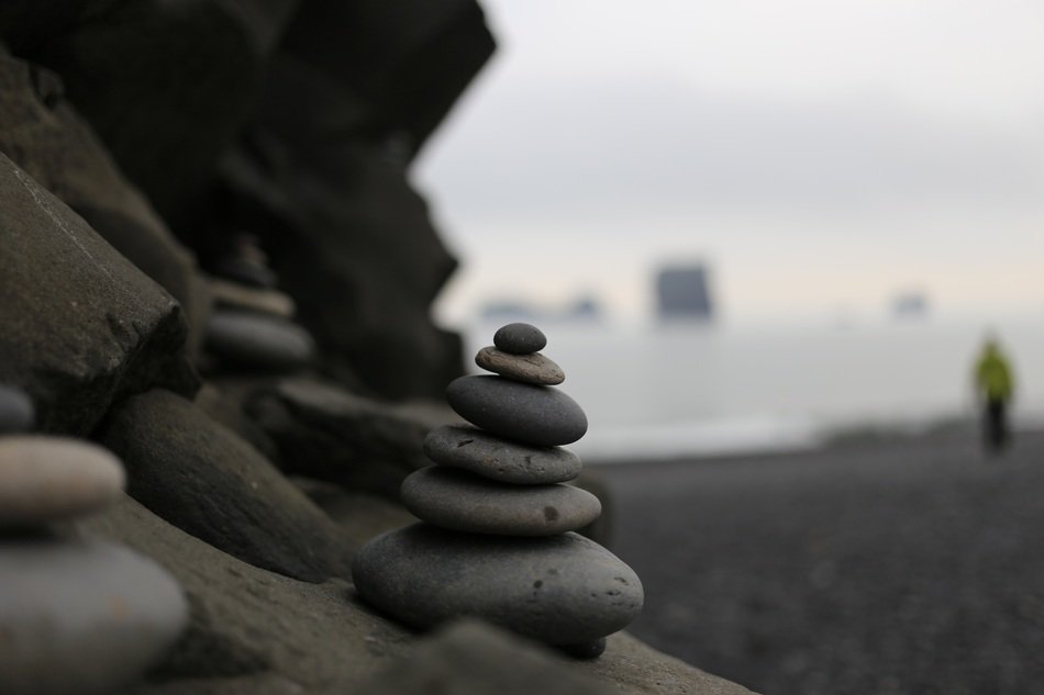 stacks of stones showing the way on beach, iceland