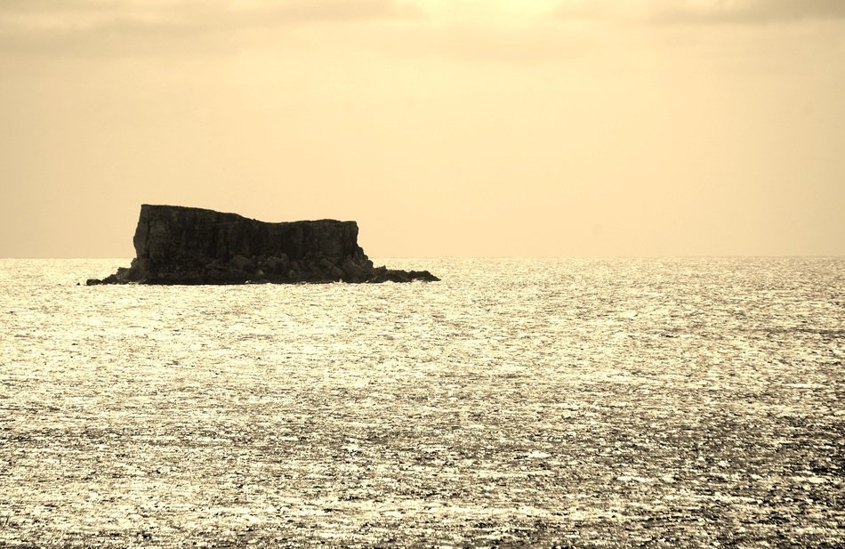 dark rock in the middle of the sea