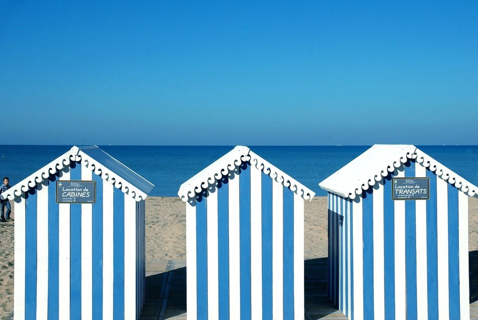 blue bathing huts on the ocean
