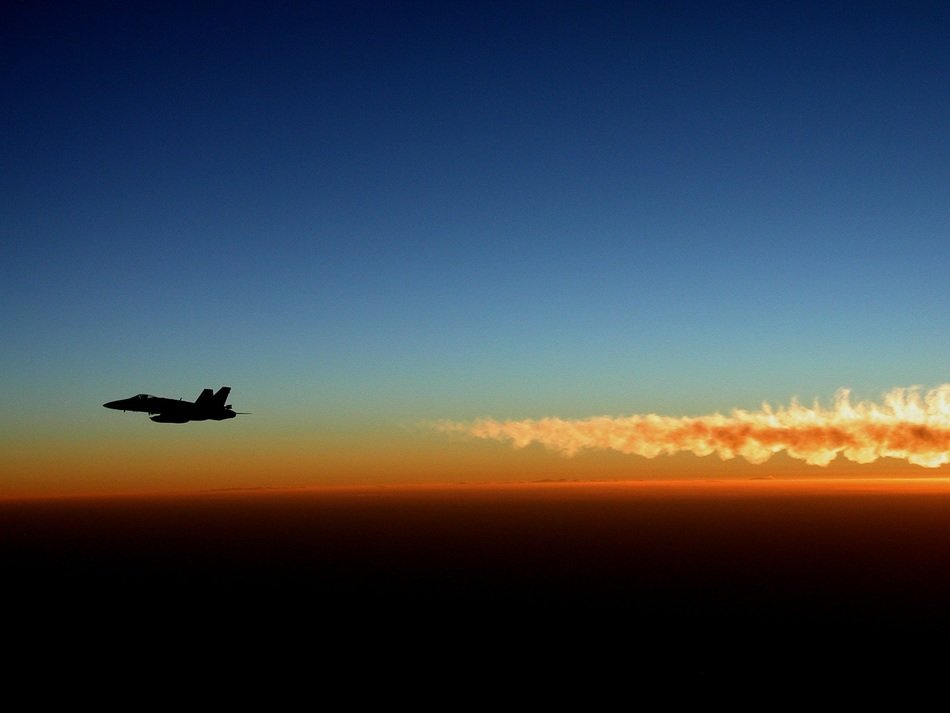 military fighter on the background of a colorful sunset