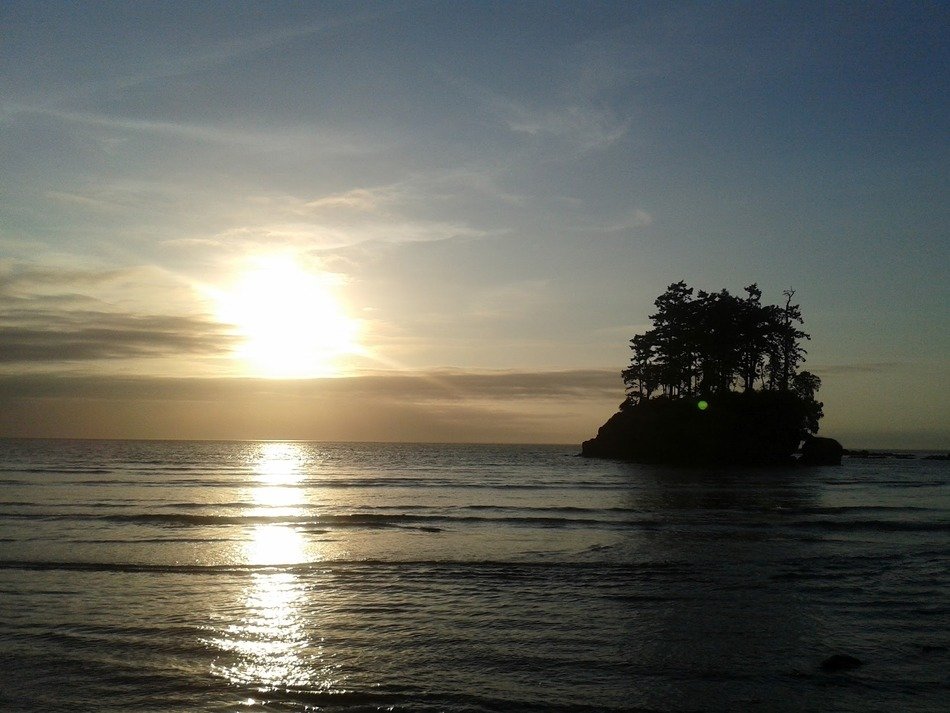 island is in middle of sea with the shine on background