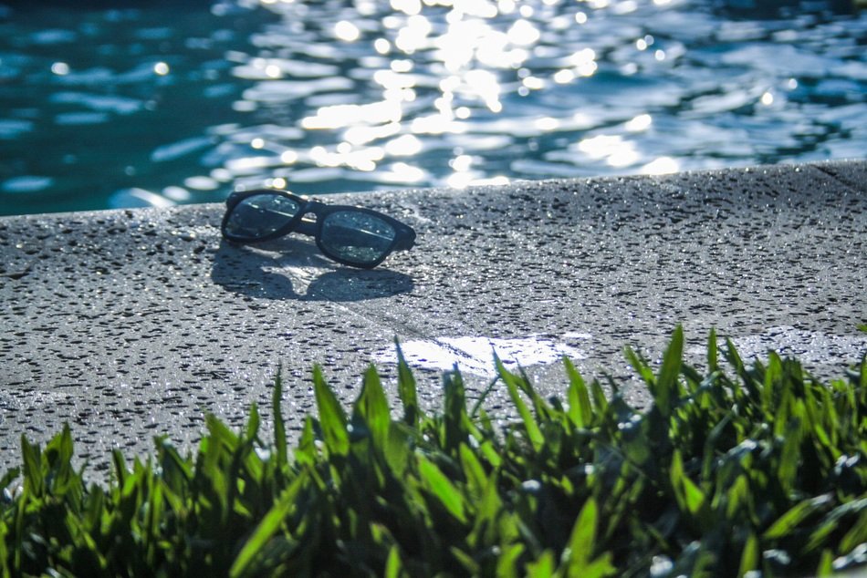sunglasses on the side of the pool