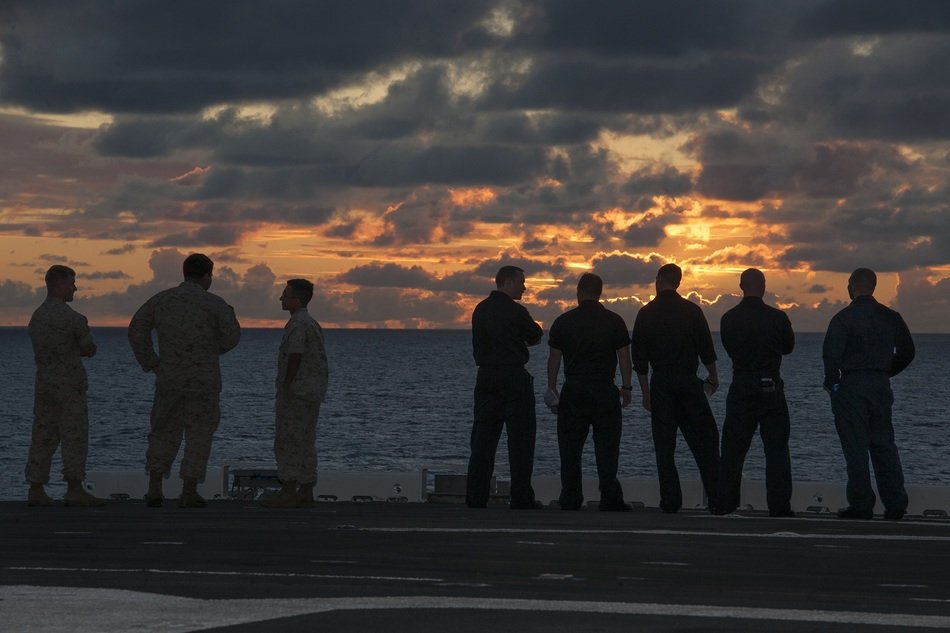 men stand on the beach during sunset