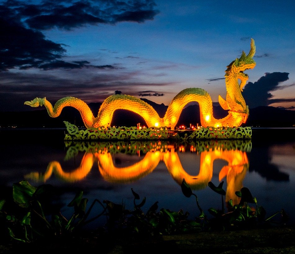 illuminated dragon figure on the lake at dusk