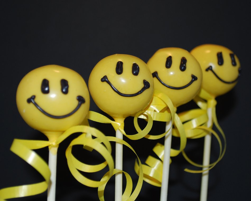 four Yummy Smiley Faces in row at darkness