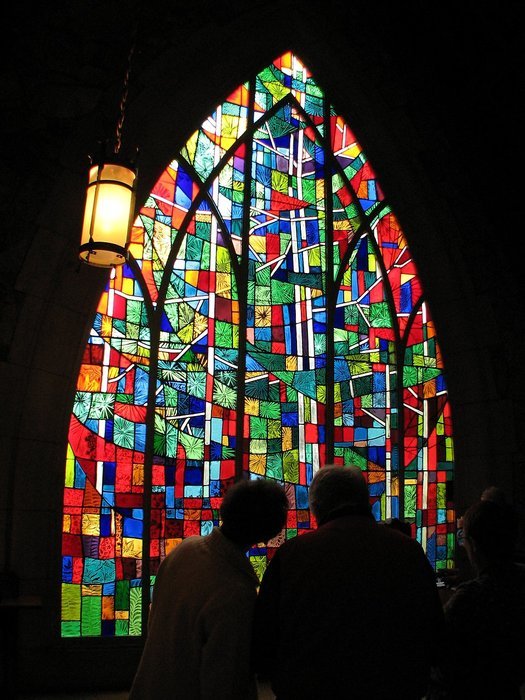silhouettes of people near a stained glass window