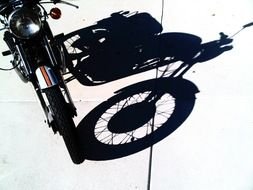 photo of a black motorcycle and its shadow