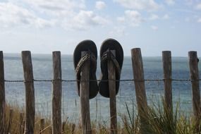 slippers on a wooden fence