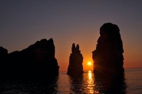 rocks in the water during sunset