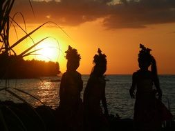 dancers on the beach against the backdrop of a golden sunset