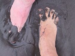 feet in black volcanic sand