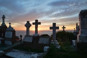 crosses and tombstones in the cemetery at sunrise