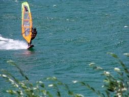 dark skin windsurfer on sea, italy, garda