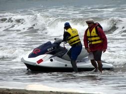 jet ski, waves and two men in life jackets