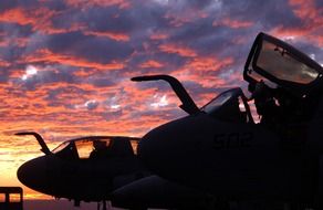silhouettes of cabins of military aircrafts at gorgeous sunset sky