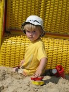 child plays with toys in the sand