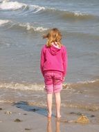 girl in a pink suit by the sea