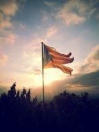 flag of catalonia over the ruins at sunset