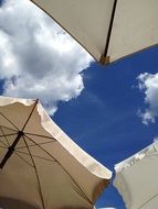 beach parasols at blue sky, bottom view