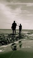 fishermen stand on the beach