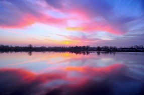 pink sunset in the clouds reflected in the lake