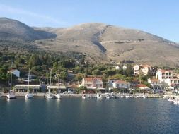 distant view from the water to the village on the island of kafelonia with the mountains