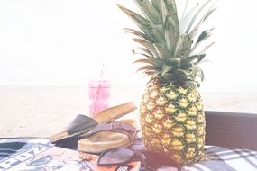 pineapple, beach slippers and sunglasses