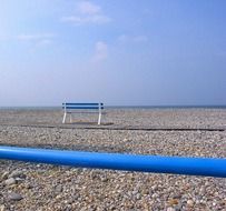 blue bench on a pebble beach