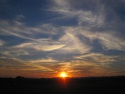 sunset, three quarter of sun orb above dark horizon