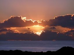 the sun in the sunset behind the clouds in the evening