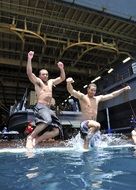 young men jumping into the pool on the ship